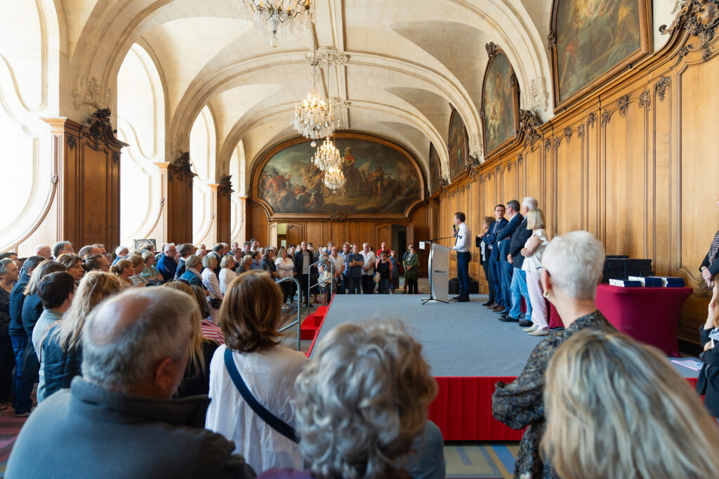 Remise de médailles pour les travailleurs de caen la mer à l'abbaye aux hommes. Les invités écoutent le discours du maire de Caen.